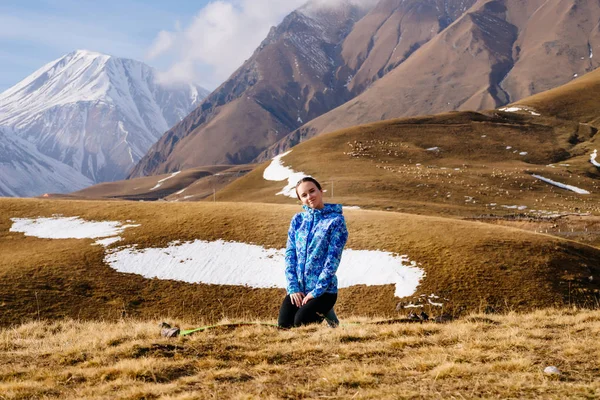 Piękne dziewczyny w Błękitnej Kurtki przemieszcza się przez góry Kaukazu, cieszy się natura — Zdjęcie stockowe