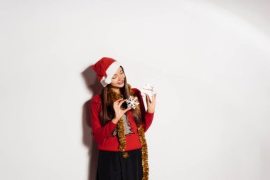 Kırmızı giysili Noel oyuncaklar elinde tutan mutlu genç kızı