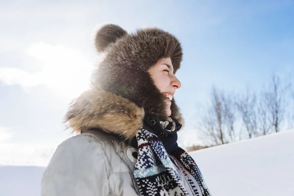 Lachen jong meisje in een bont hoed is reizen in het koude noorden — Stockfoto