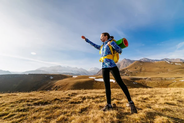 Joven activa en una chaqueta azul viaja a través de las montañas del Cáucaso con una mochila —  Fotos de Stock