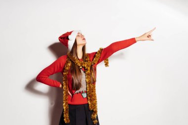 Kendine güvenen kız kırmızı bir kazak ve bir kap içinde bir yerlerde gösterir parmağıyla, Noel bekliyor