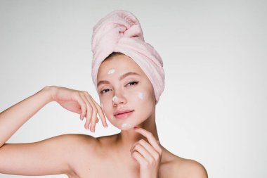 Kadın krem yüz duş sonra başında havlu ile