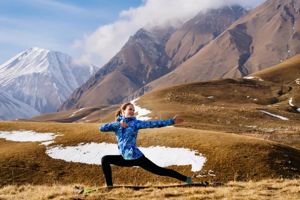 Щаслива жінка турист на фоні високих гір робить вправи — стокове фото