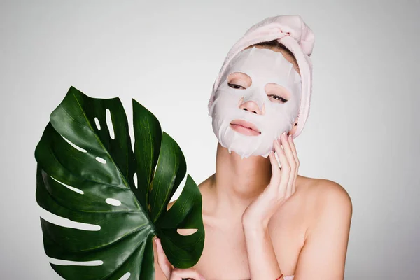 Wanita dengan handuk di kepalanya setelah mandi menerapkan masker pelembab di wajah — Stok Foto