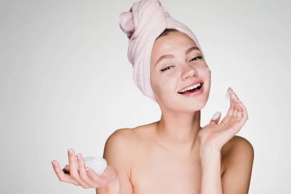 Boldog asszony egy törülközőt a fején, a habot az arcán zuhanyozás után — Stock Fotó