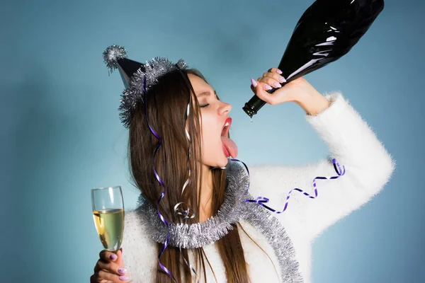 Berusad kvinna i en festlig hatt rymmer en flaska i handen — Stockfoto