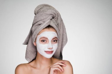 kadın duş temizleyici maske yüzünde uygulayıp sonra başında bir havlu ile
