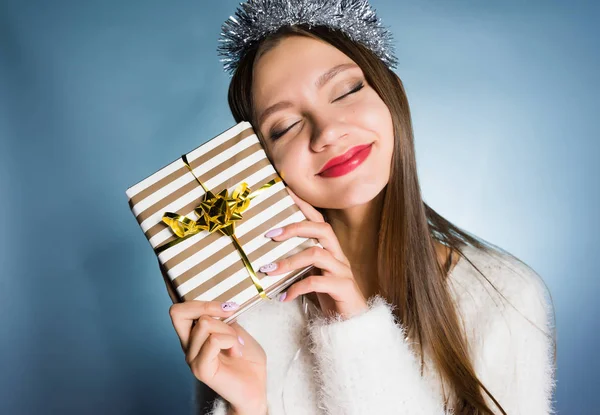 Gelukkige vrouw met een feestelijke cap houden een doos met een gift op haar handen — Stockfoto