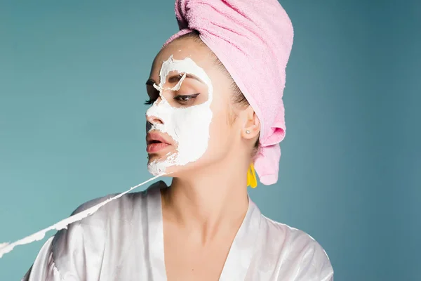 Mulher com uma toalha na cabeça tira a máscara facial — Fotografia de Stock