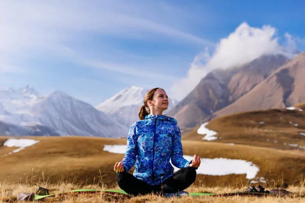 Touristin meditiert vor dem Hintergrund der Berge — Stockfoto
