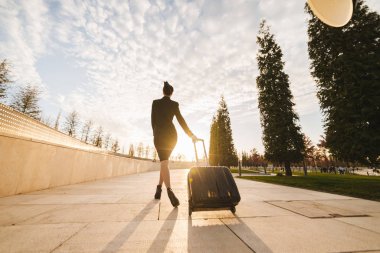 Üniformalı kadın uçuş görevlisi büyük bir çantayla gelir