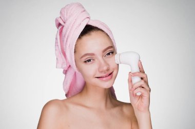 kafa havluya mutlu kadınla derin girdap için fırça ile yüz cildi temizler