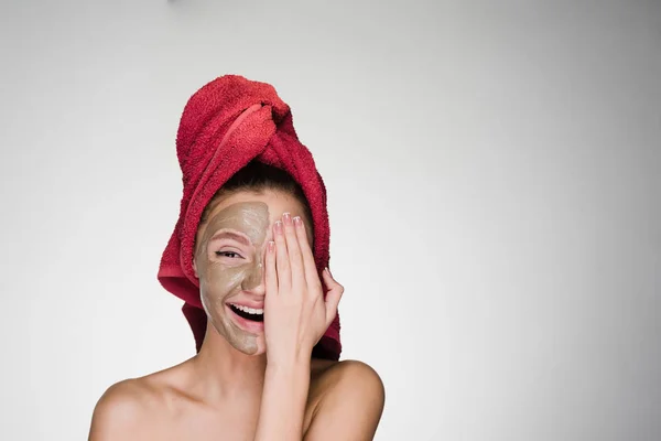 Mujer feliz con toalla en la cabeza después de la ducha aplicado máscara en la piel de la cara — Foto de Stock