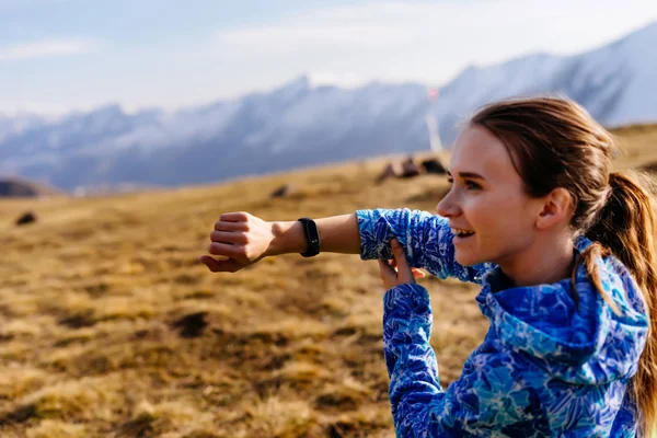 Lycklig kvinna turist sitter visar fitness armband — Stockfoto