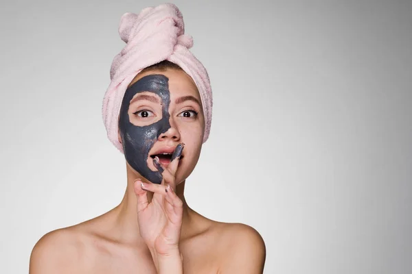 Mujer con una toalla en la cabeza se ha puesto una máscara en la cara — Foto de Stock