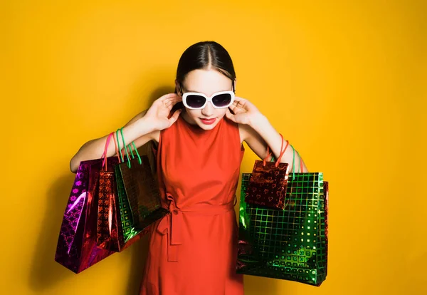 Donna in abito rosso in possesso di borse della spesa — Foto Stock