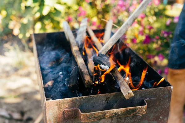 Firewood queima em um churrasco no fundo da natureza — Fotografia de Stock