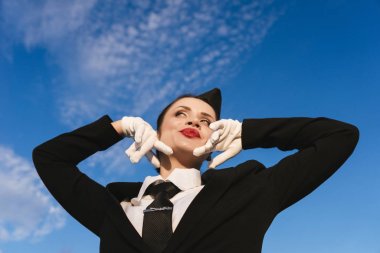 kamera gökyüzü arka plan üzerinde üniforma poz içinde mutlu kadın hostes