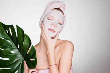 bir kadın duş sonra başında bir havlu ile yüz maskesinin koymak