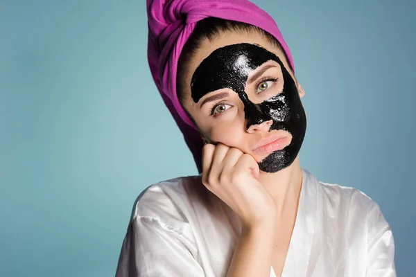 Mujer triste con una toalla en la cabeza después de ducharse con una máscara en la cara — Foto de Stock