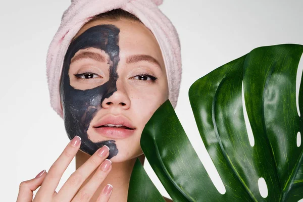 Kobieta z ręcznikiem na głowie po prysznic stosuje się oczyszczanie maski na twarz — Zdjęcie stockowe