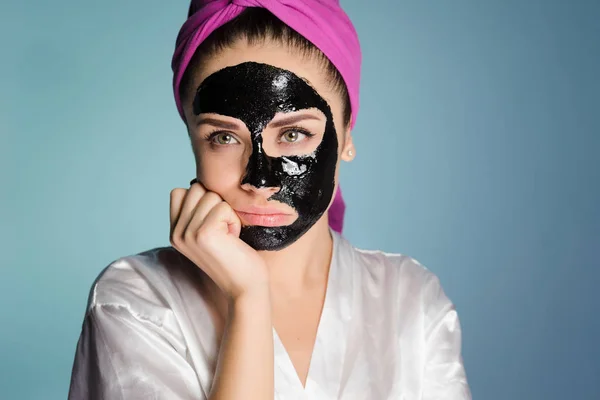 Una mujer con una toalla en la cabeza después de ducharse se puso la mascarilla — Foto de Stock