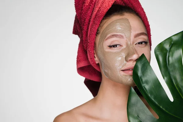 Mujer con una toalla en la cabeza después de la ducha se aplicó una máscara para limpiar la piel — Foto de Stock