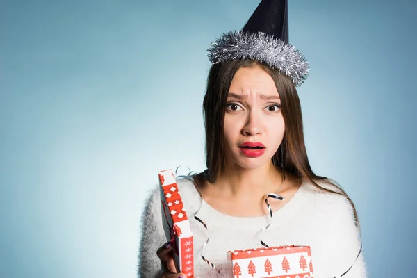 Грустная молодая девушка в новогодней кепке, недовольная подарком — стоковое фото