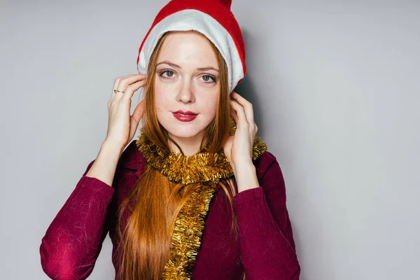 Mujer en un sombrero de Navidad sobre un fondo gris —  Fotos de Stock