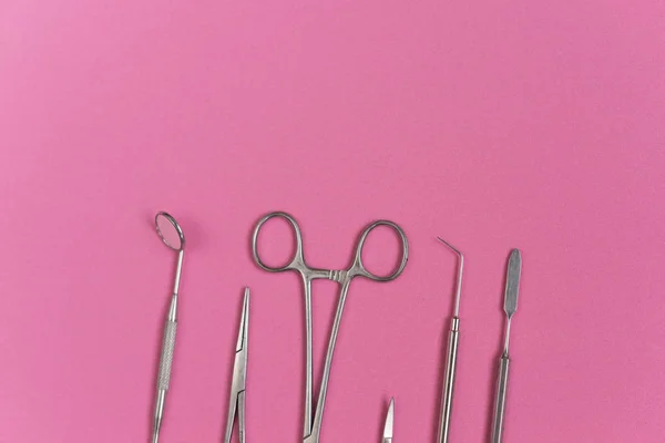 Стерильні зубні інструменти на рожевому фоні — стокове фото