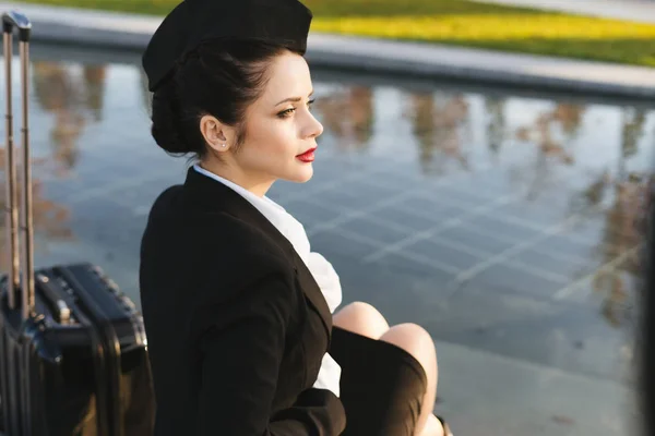 Letuška žena v uniformě sedí na schodech — Stock fotografie