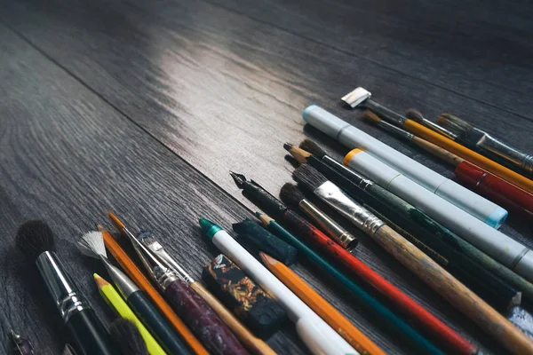 Na mesa de design estão pincéis, lápis — Fotografia de Stock