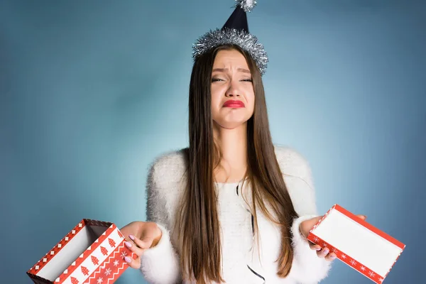 A frustrated woman in a festive hat holds an empty gift box — Stock Photo, Image