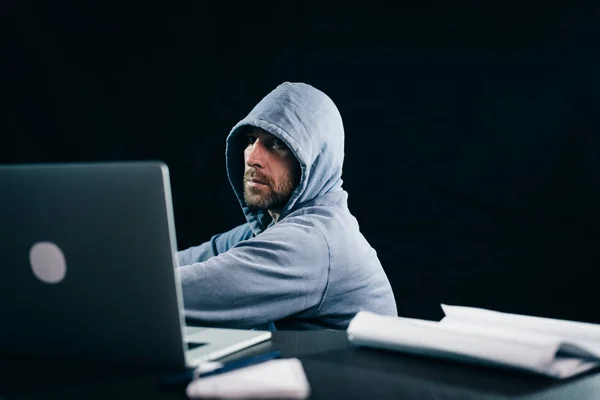 Masada oturan bir kukuleta ile bir kazak erkek hacker — Stok fotoğraf