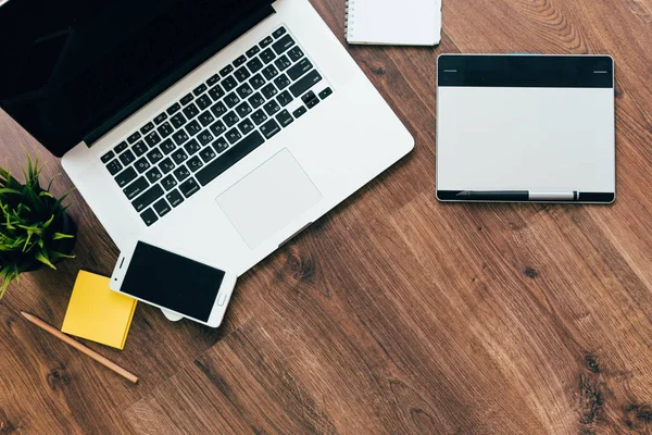 Op de design tafel is een laptop, telefoon — Stockfoto