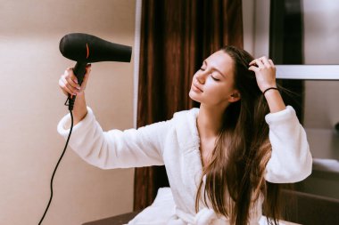 Sadece onu duştan geldi bir kadın onun saç kurutma