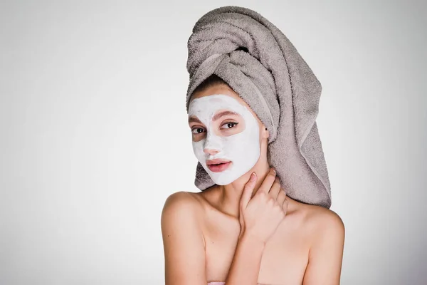 Femme avec une serviette sur la tête appliquer un masque nettoyant sur la peau du visage — Photo