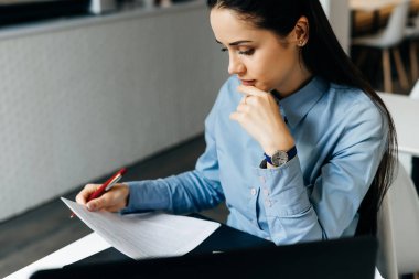 kadın ofiste oturan ve belgeleri seyir