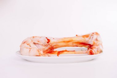 Beyaz bir arka plan bir tabağa kemirilmiş kemik yatıyor