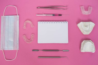 a lot of dental instruments lie on a pink table clipart