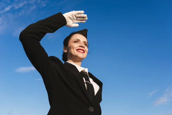 Glücklich Stewardess in Uniform auf dem Himmel Hintergrund — Stockfoto