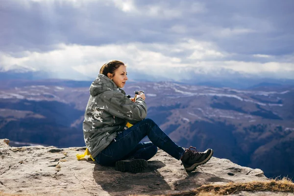 Kadın turist dağlar bir arka plan üzerinde çay içer — Stok fotoğraf