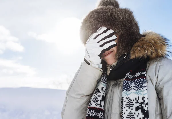 Kobieta w zimowy kombinezon pokryty oczy jej rękę — Zdjęcie stockowe