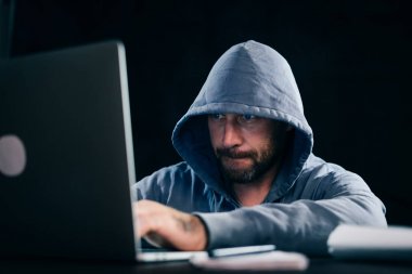 karanlık odada oturan ve laptop arıyorum erkek hacker