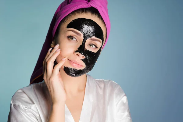 Kobieta z ręcznikiem na głowie po kąpieli, umieścić na jej twarzy maski — Zdjęcie stockowe
