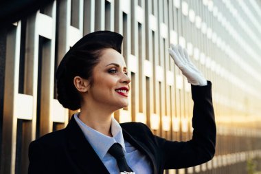 mutlu kadın hostes elini sallayarak üniformalı