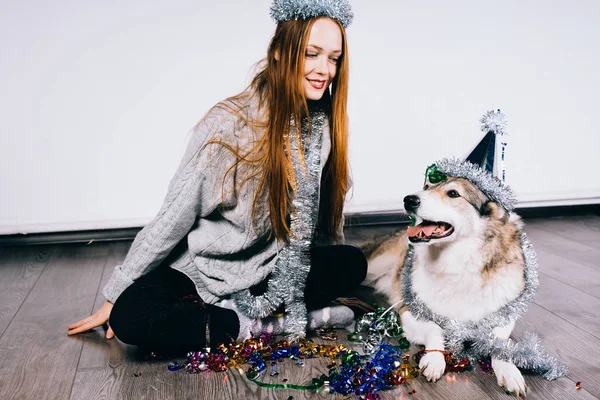 Mujer feliz en un sombrero festivo acariciando a un perro — Foto de Stock