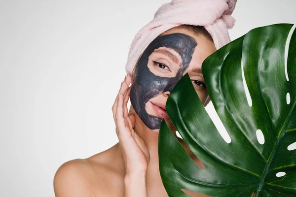 Frau mit Handtuch auf dem Kopf hat sich eine Maske über das Gesicht gezogen — Stockfoto