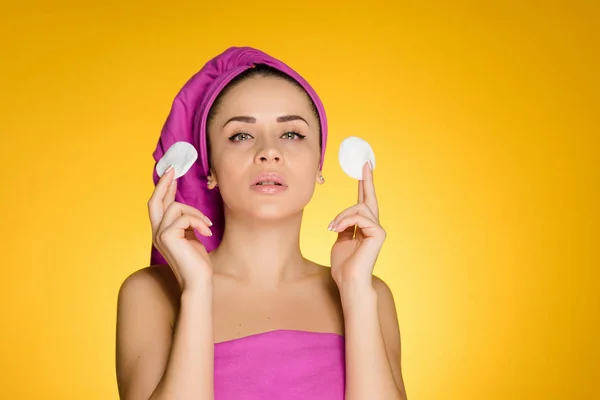 Woman with a towel on her head holds in hands cotton balls — Stock Photo, Image