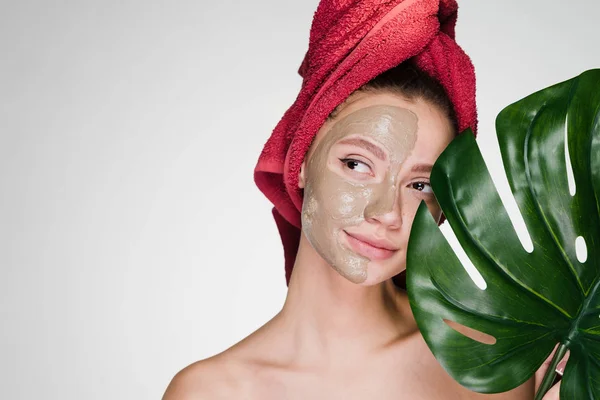 Vrouw met een handdoek op haar hoofd een reinigende masker toepassen op de huid van het gezicht — Stockfoto